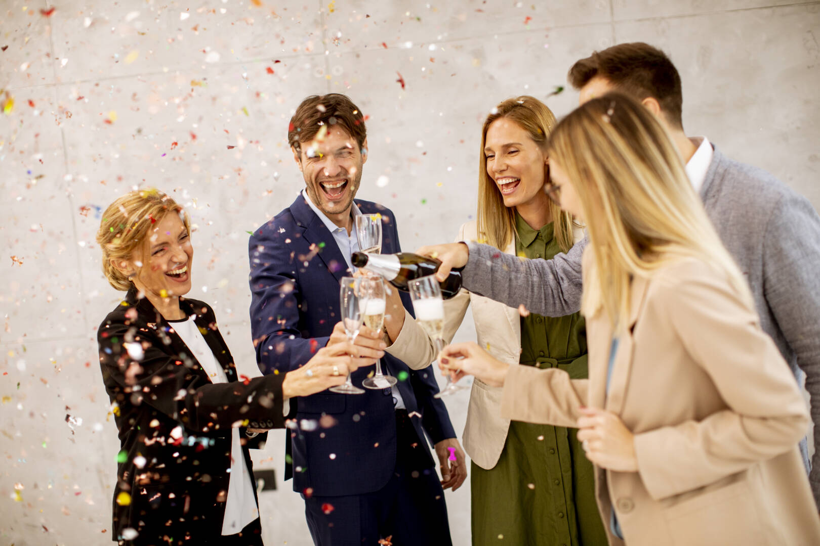 Group of business people celebrating and toasting with confetti