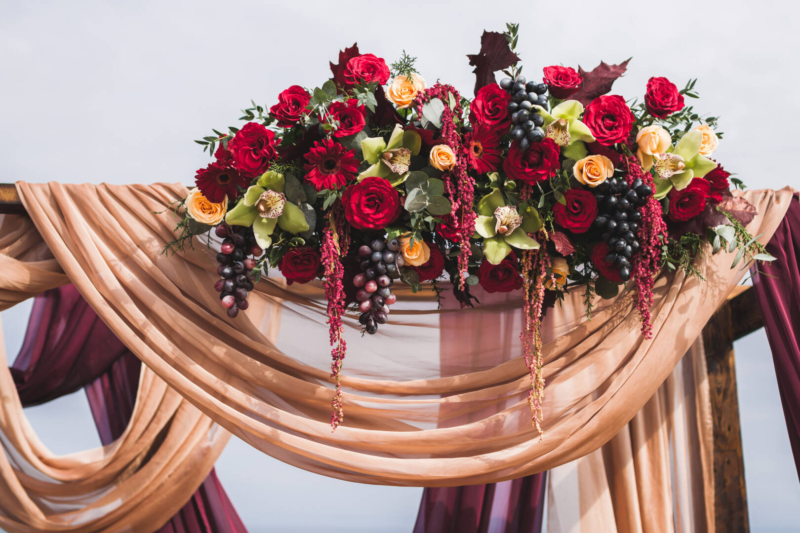 Wedding ceremony in Boho style, decorated with red roses, yellow